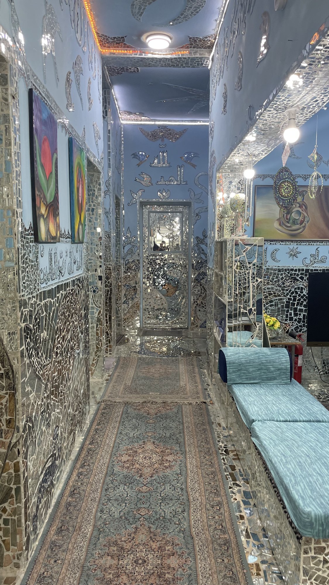 ممرٌّ مكسوٌّ بالمرايا تزيّنه اللوحات